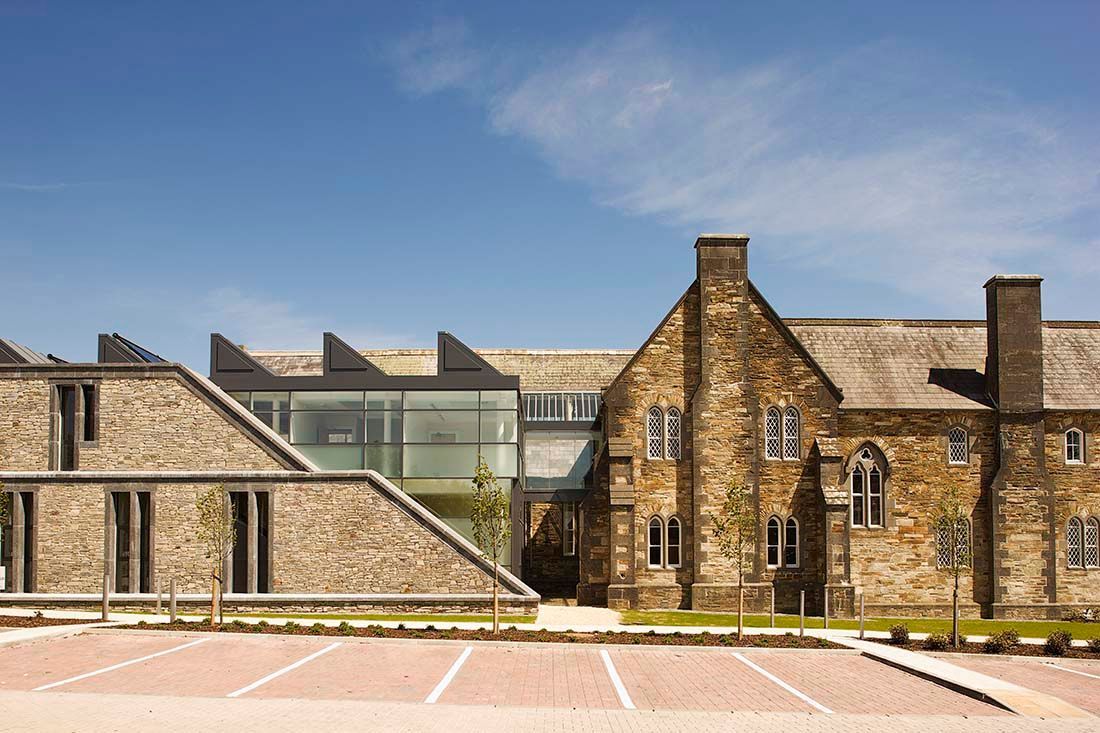 A large stone building with a parking lot in front of it