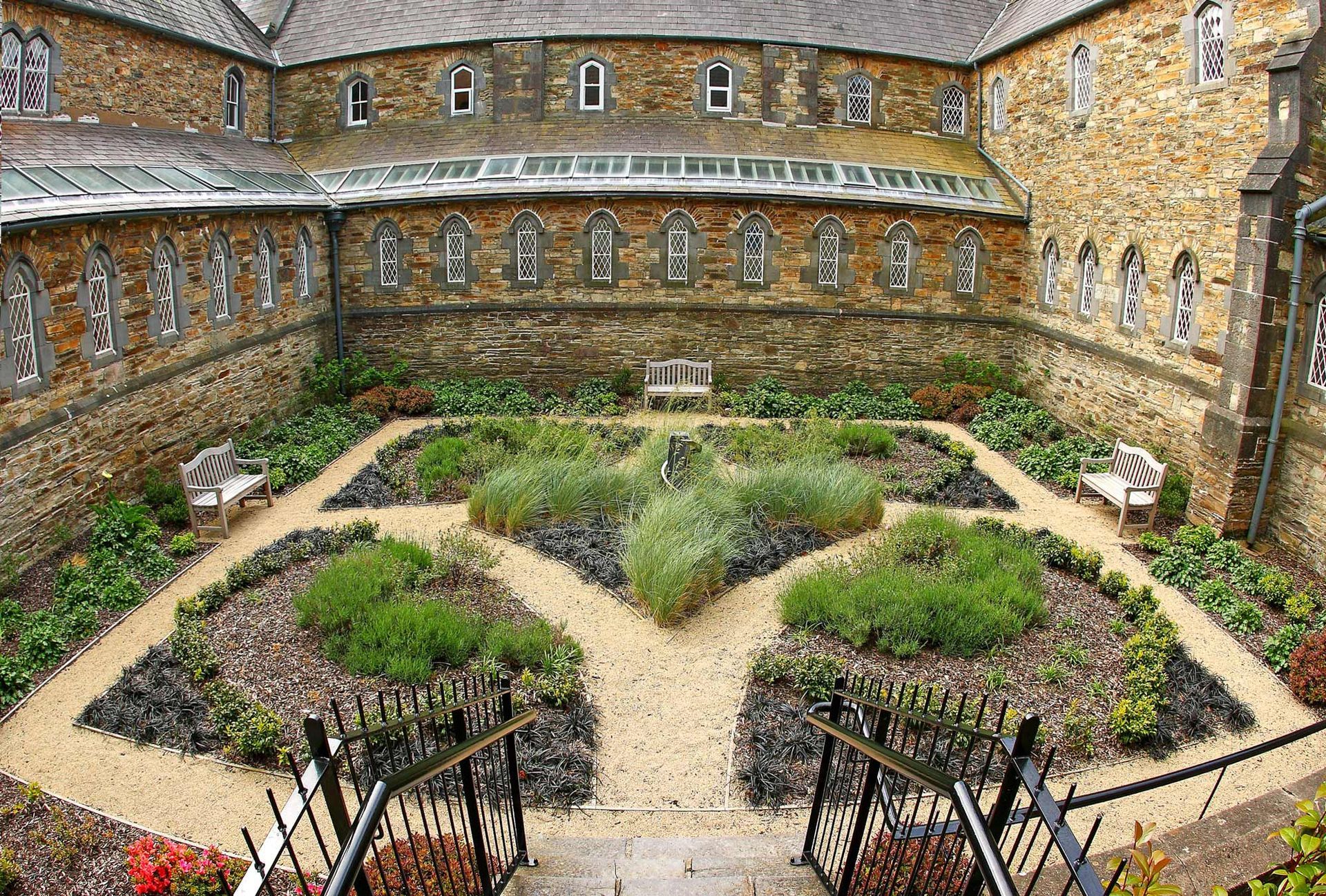 A large stone building with a garden in the middle of it