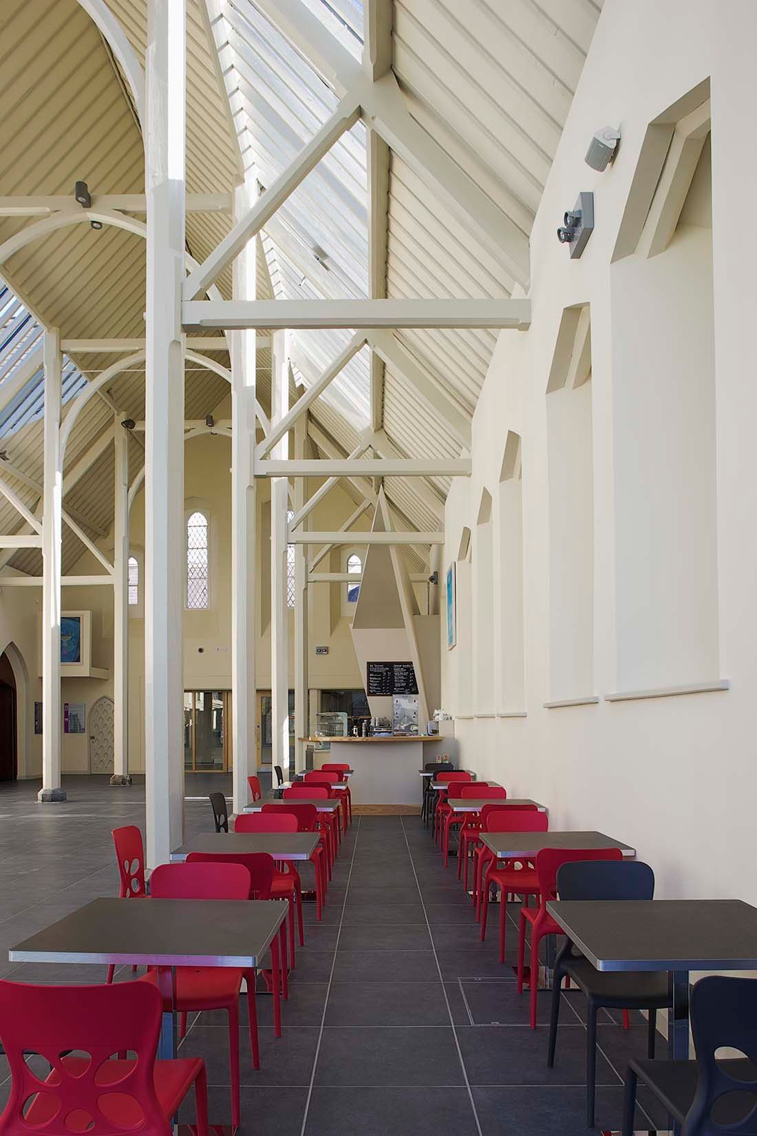 A long hallway with tables and chairs in a building
