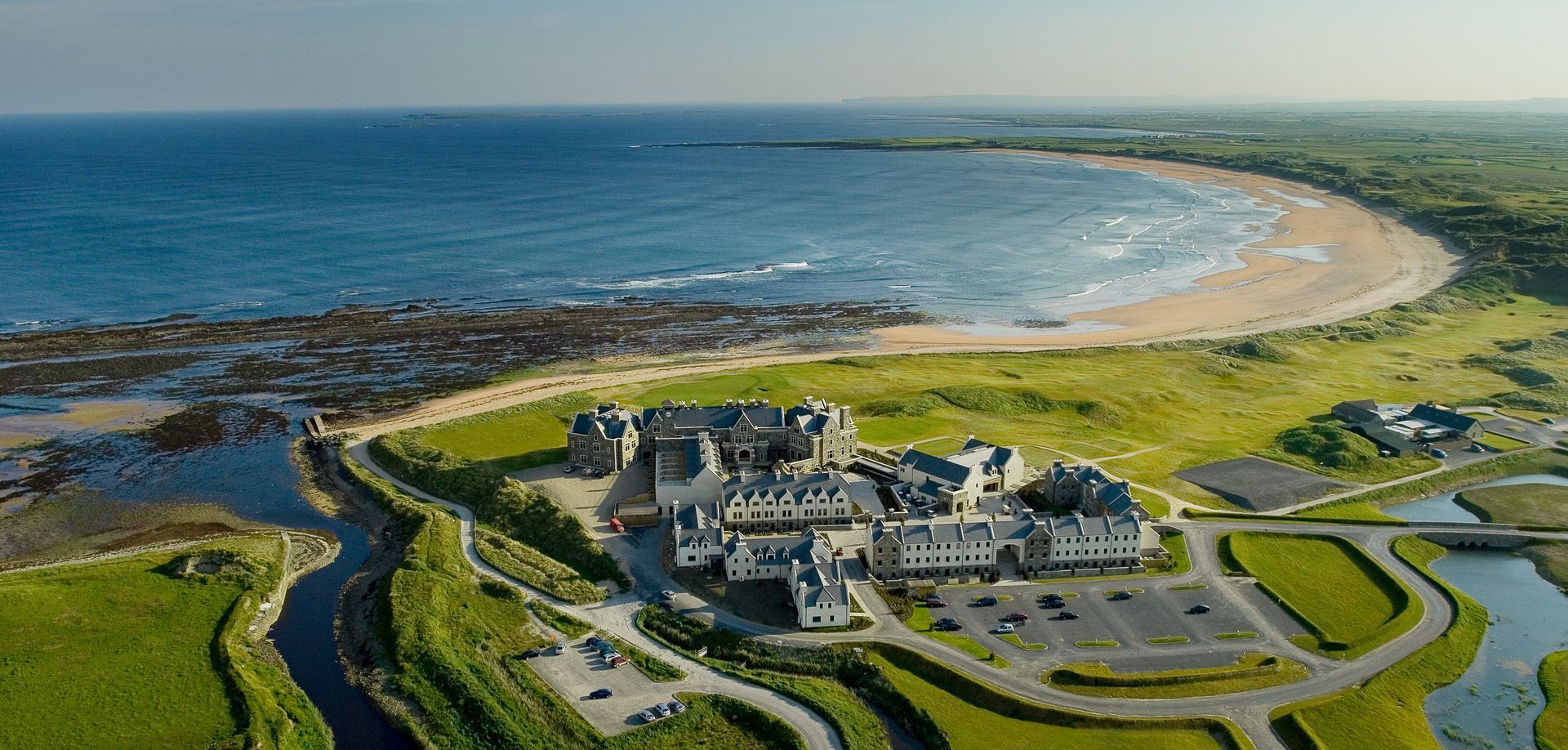 An aerial view of a golf course next to the ocean.