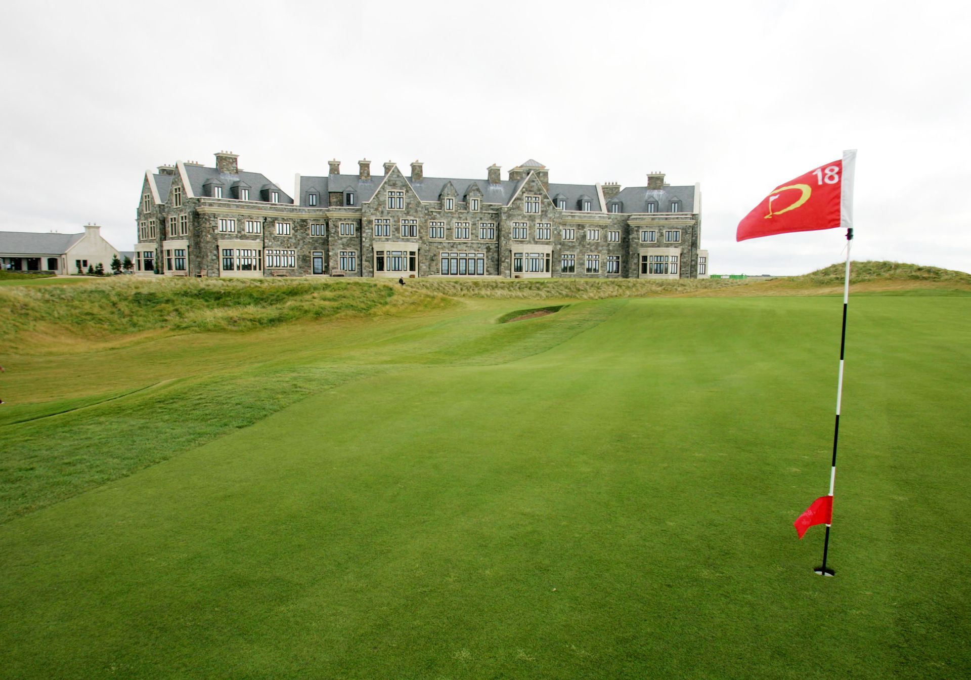 A golf course with a large building in the background