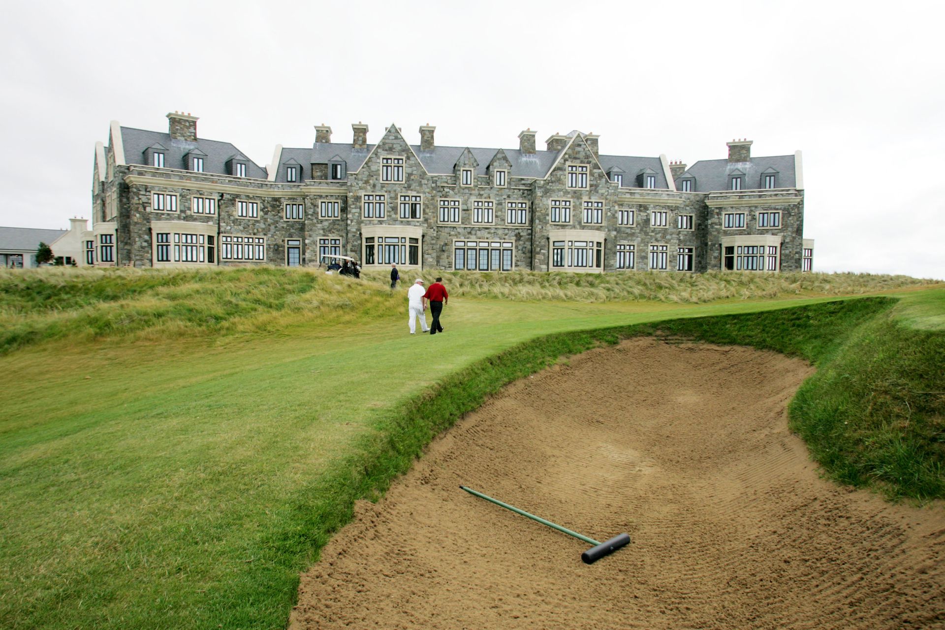 A golf course with a large building in the background