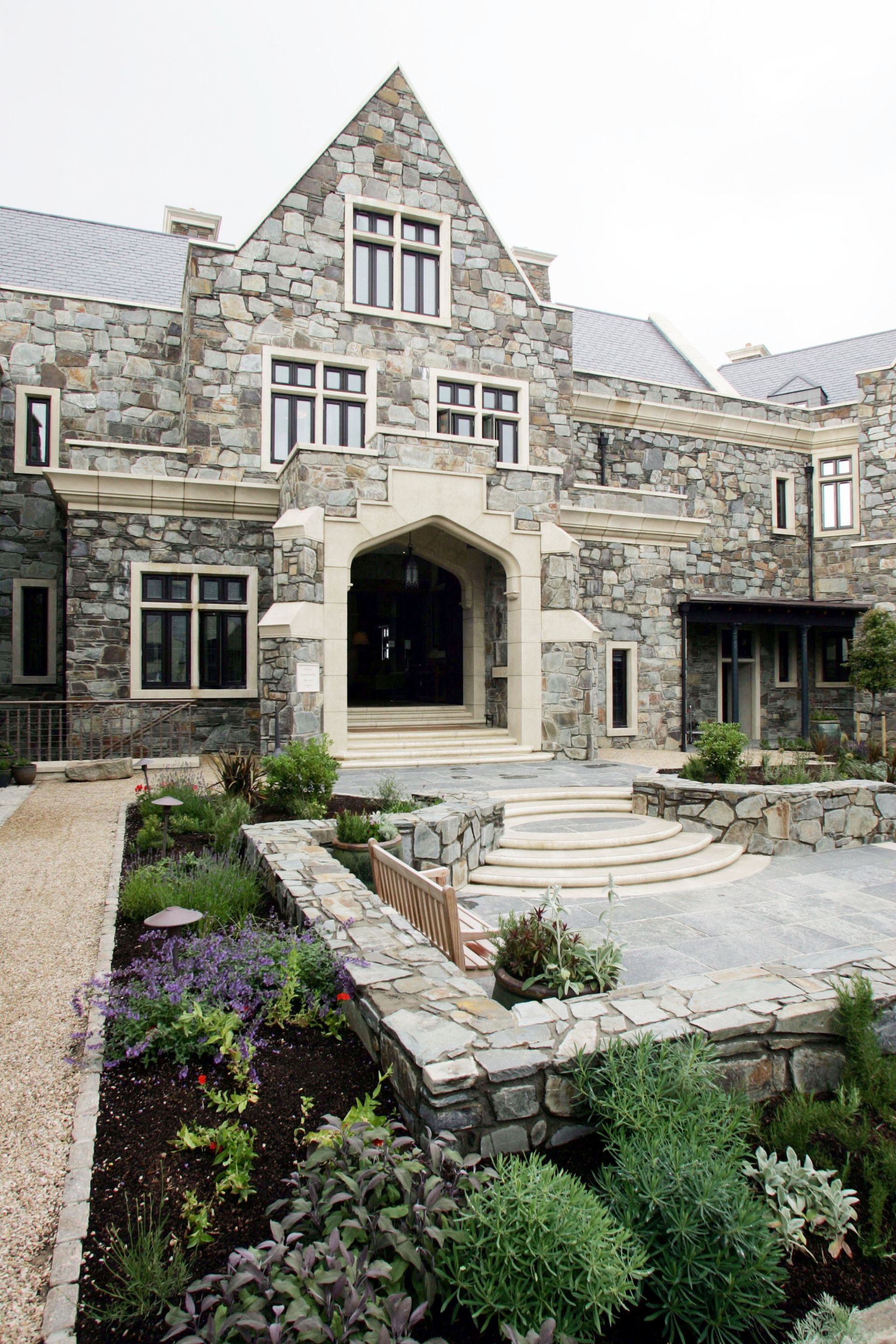 A large stone building with a bench in front of it