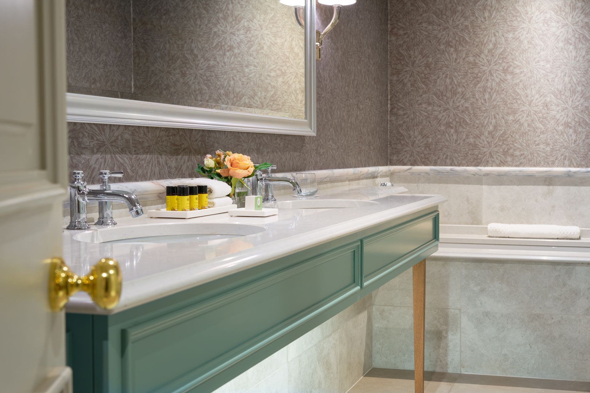 A bathroom with two sinks , a mirror and a bathtub.