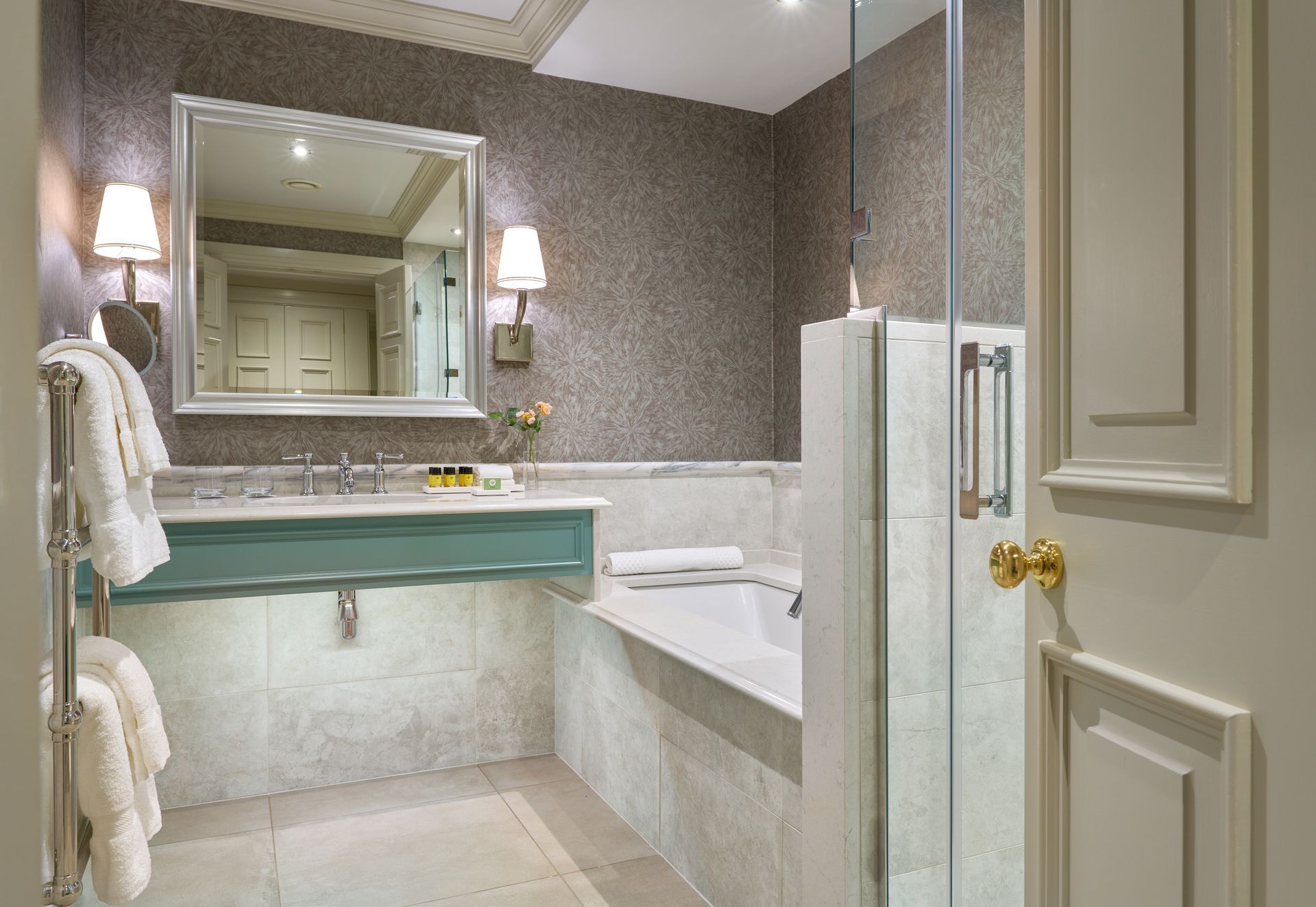 A bathroom with a tub , sink , mirror and shower.