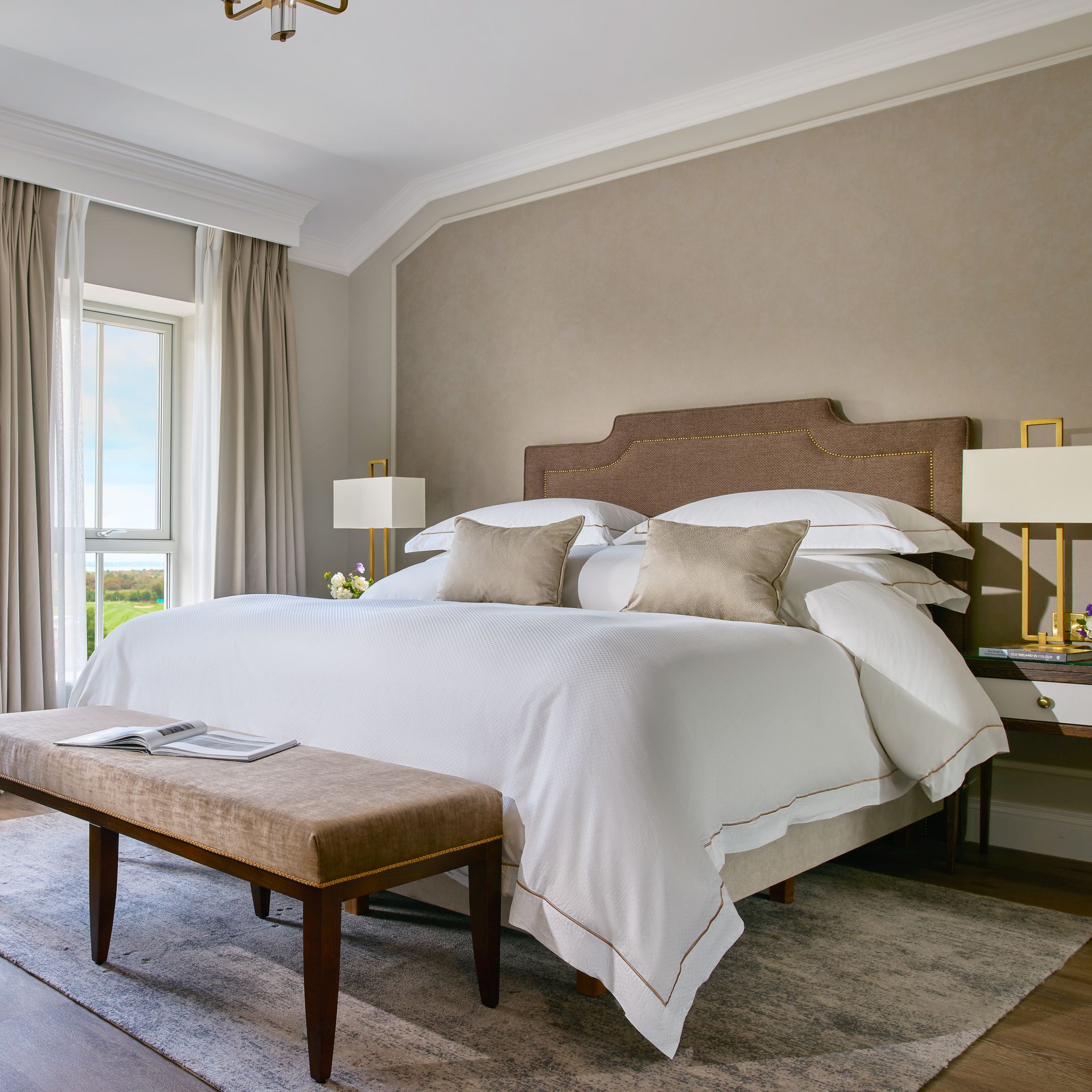 A bedroom with a large bed and a bench