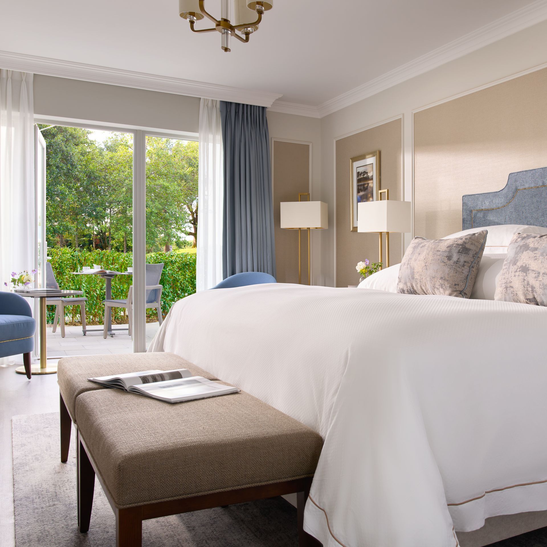 A hotel room with a large bed and a bench