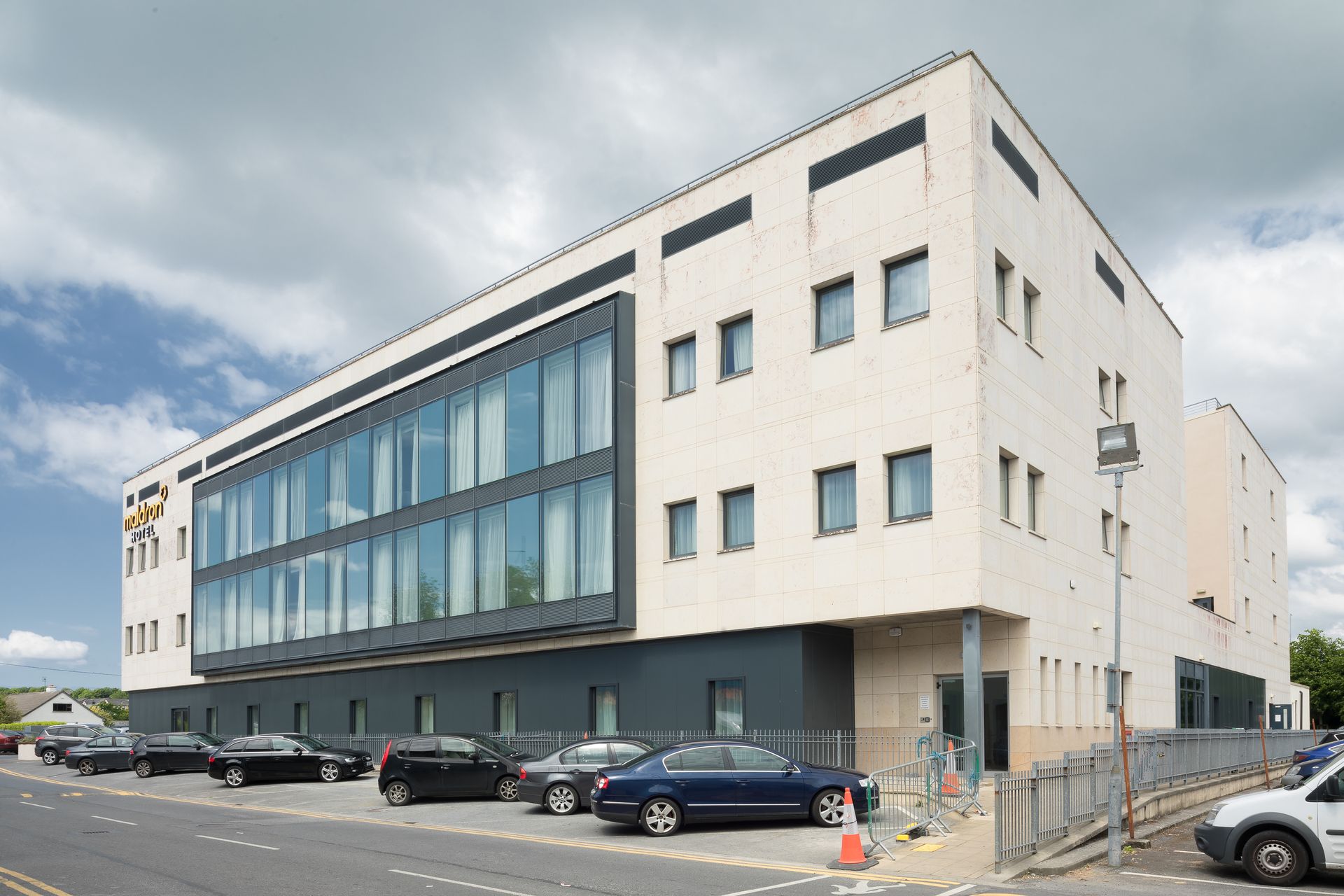 A large building with a lot of windows and cars parked in front of it.