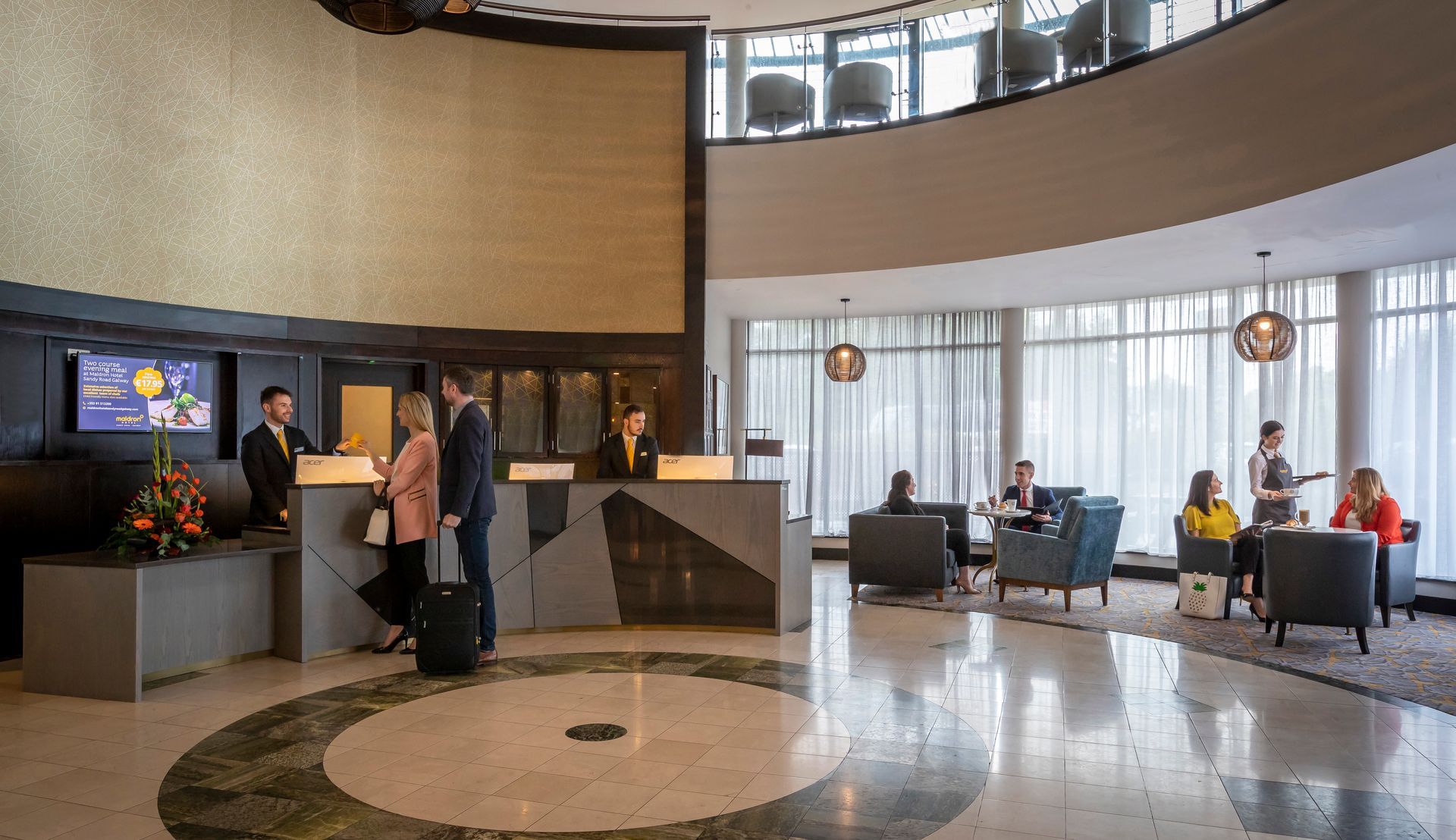 A group of people are standing in a lobby of a hotel.