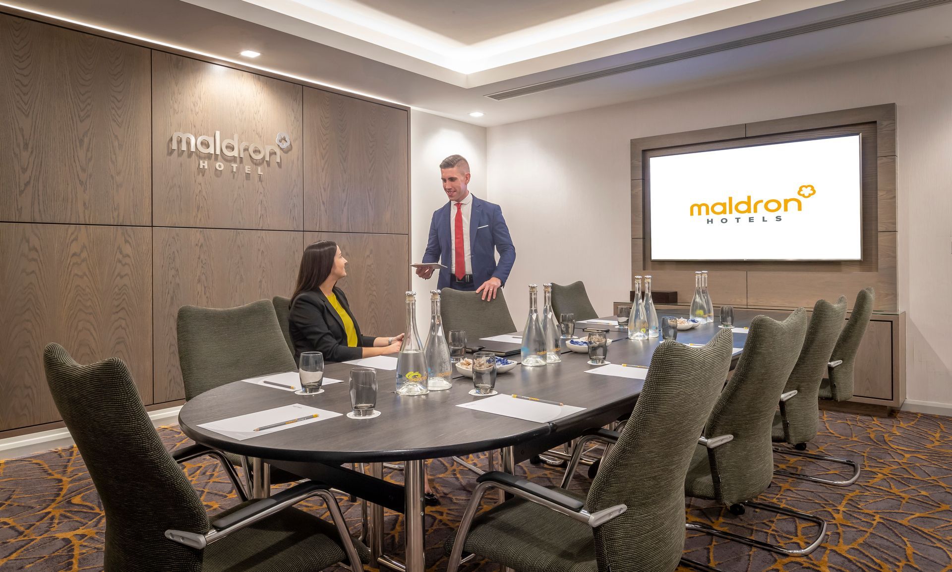 A man and a woman are having a meeting in a conference room.