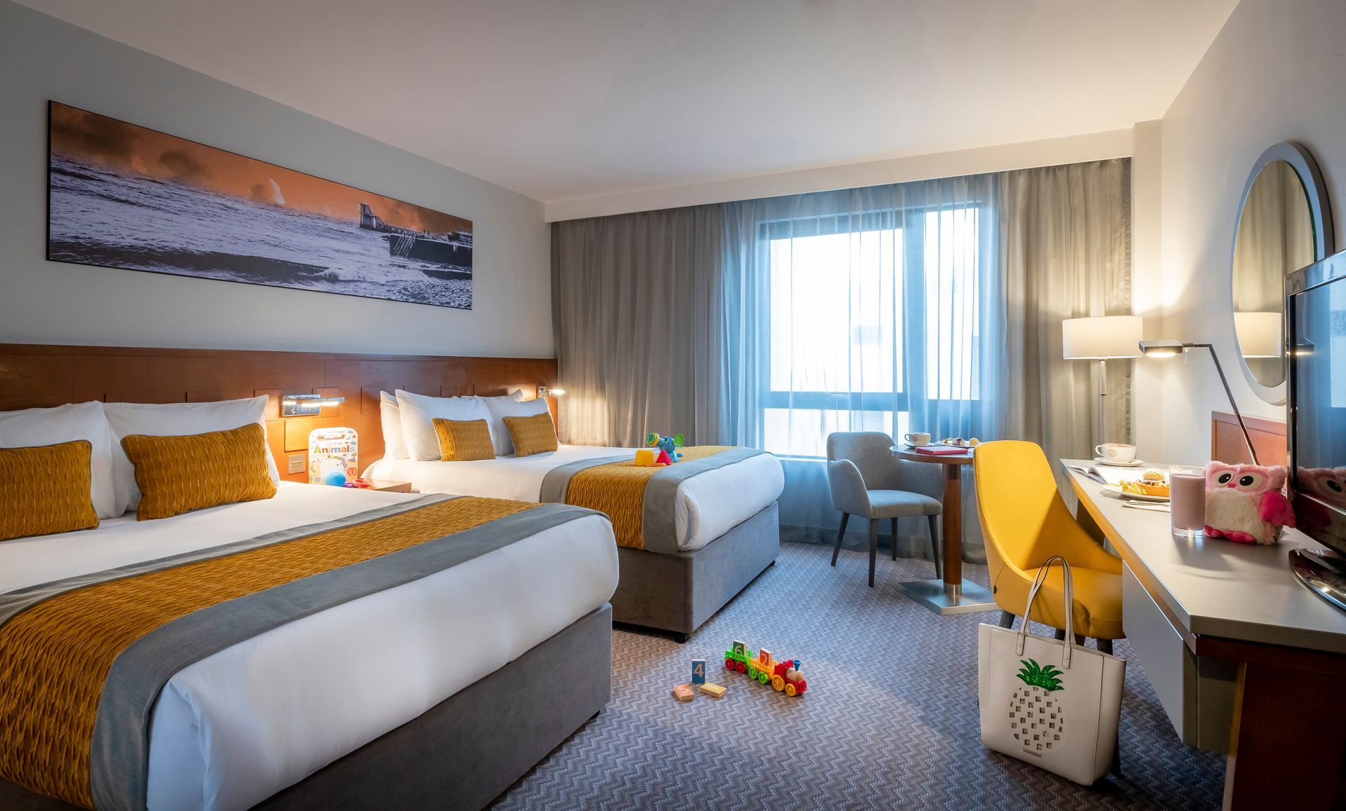 A hotel room with two beds , a desk , a chair and a television.