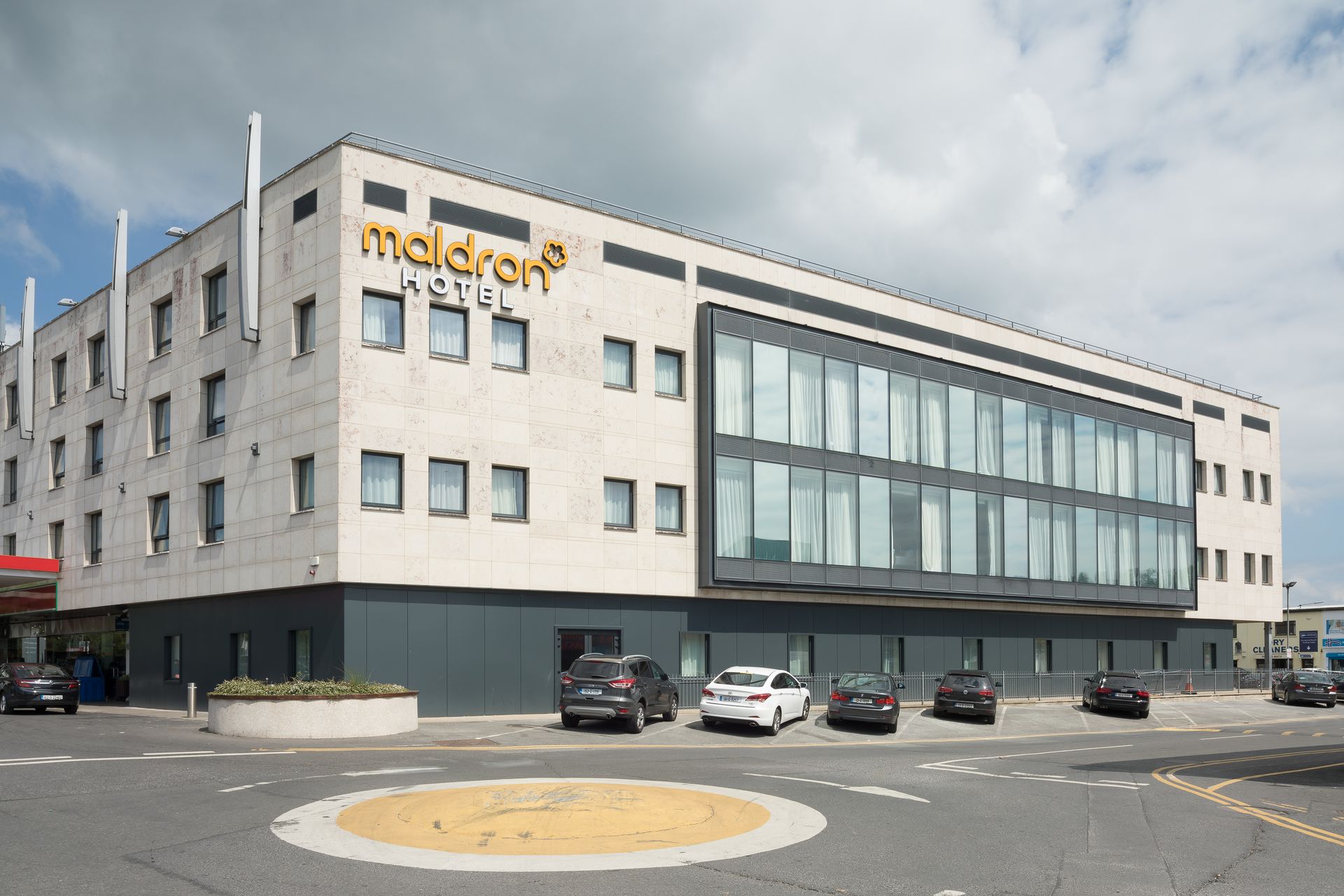 A large building with a lot of windows and cars parked in front of it