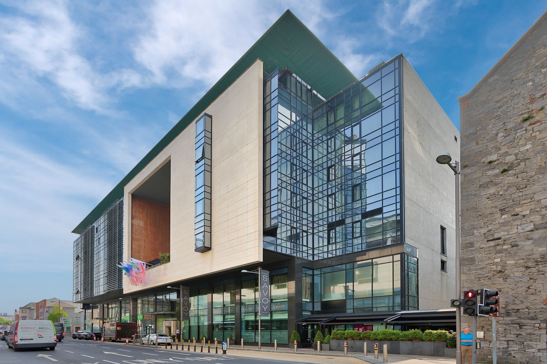 A large building with a lot of windows is on the corner of a street