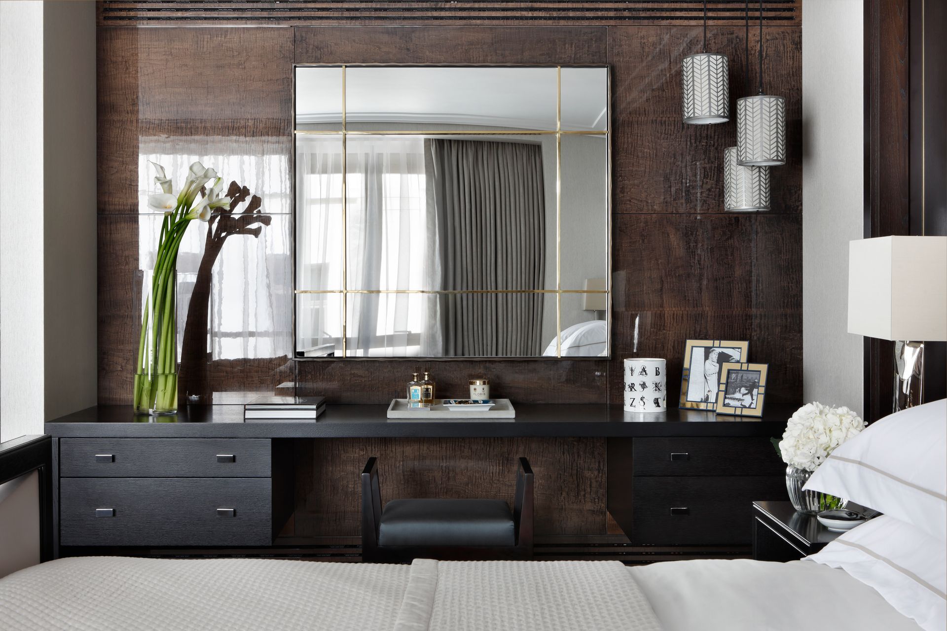 A bedroom with a large mirror on the wall above the bed