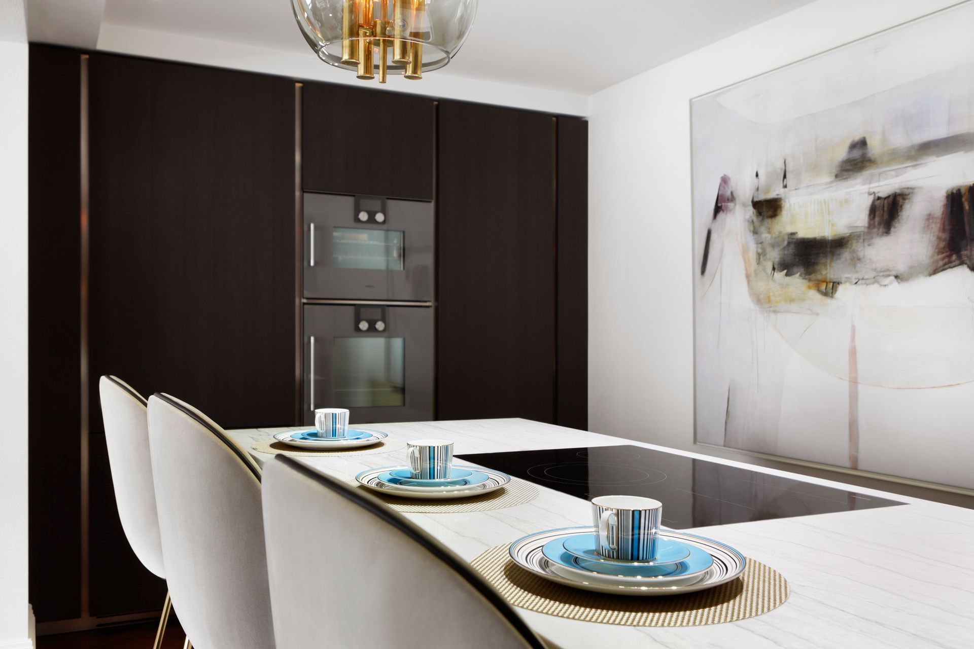 A kitchen with a stove top oven and a painting on the wall