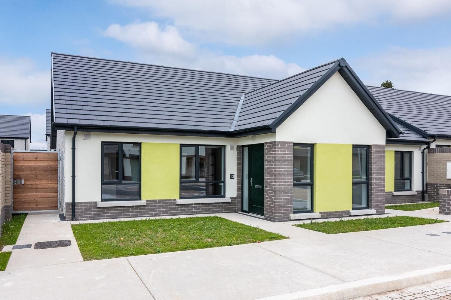 A small house with a gray roof and yellow trim