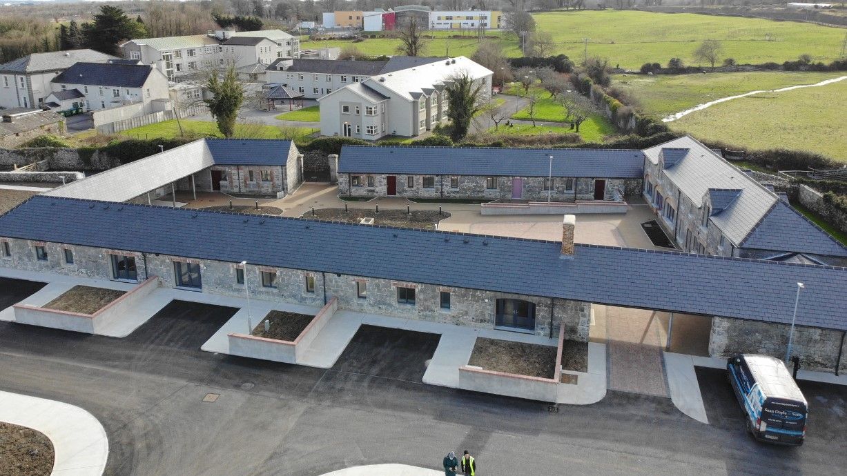 An aerial view of a large building with a blue roof