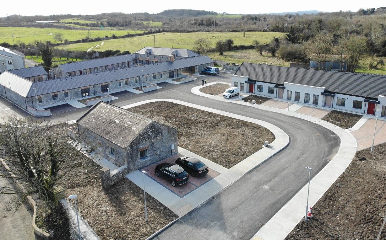 An aerial view of a house with cars parked in front of it.