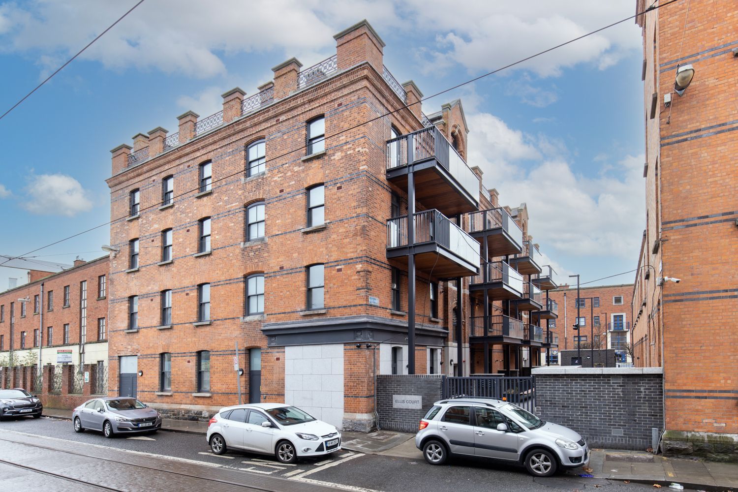 A brick building with cars parked in front of it.