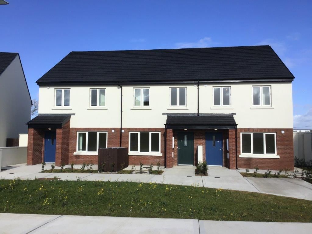 A white and brick house with a black roof
