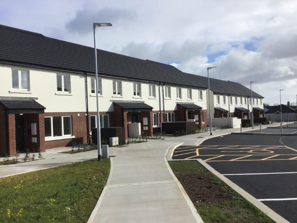 A row of houses with a concrete walkway between them