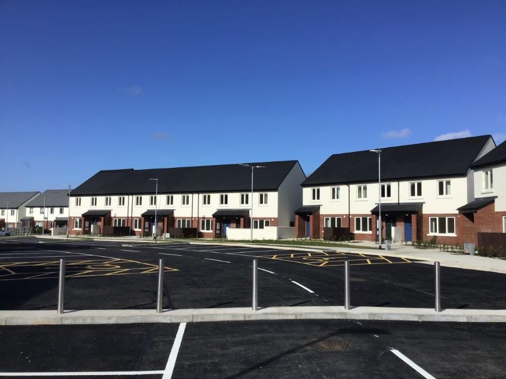 A row of houses with a parking lot in front of them
