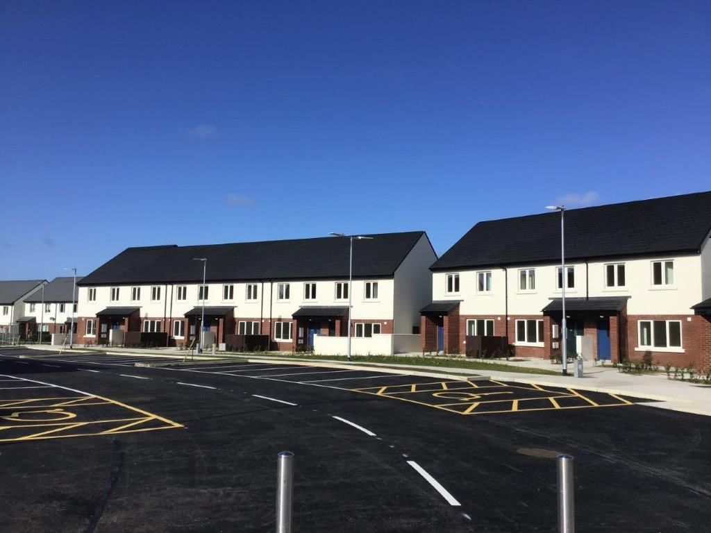 A row of houses with a parking lot in front of them