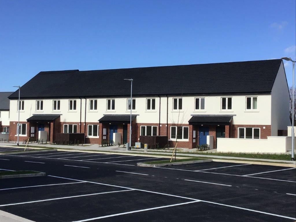 A row of houses with a parking lot in front of them