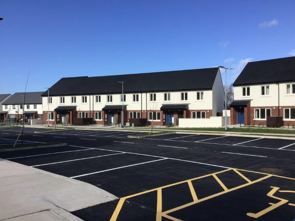 A row of houses with a handicapped parking spot in front of them