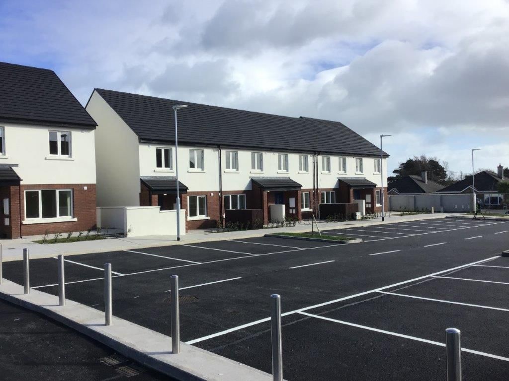 A row of houses with a parking lot in front of them