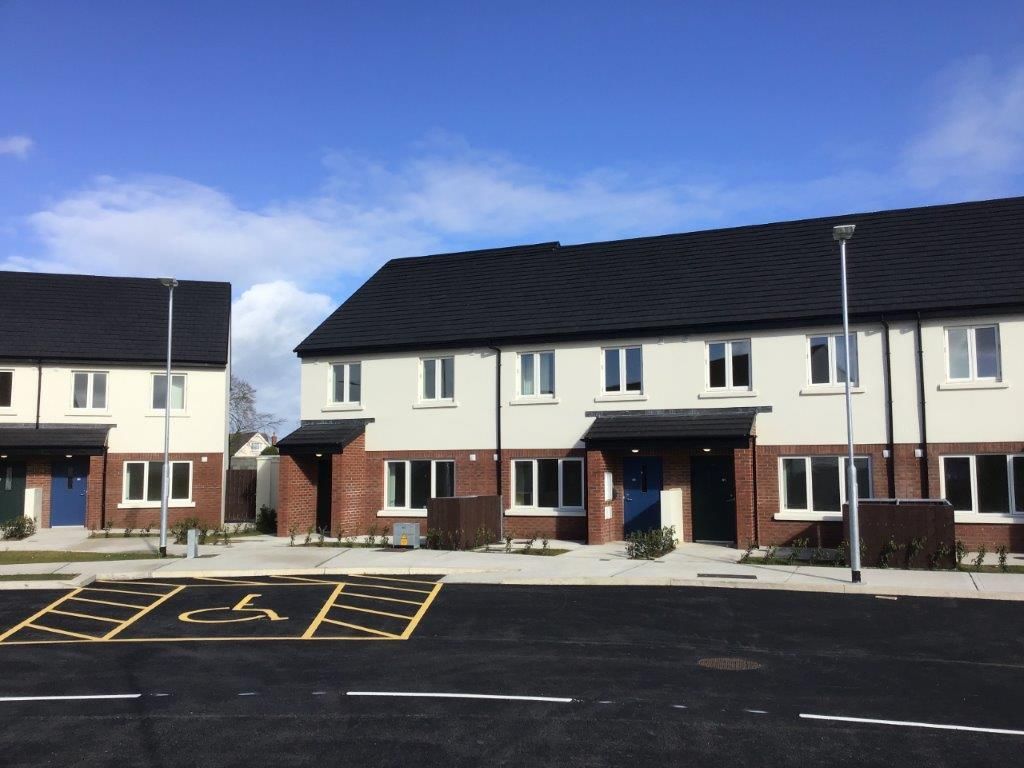 A row of houses with a handicapped parking spot in front of them