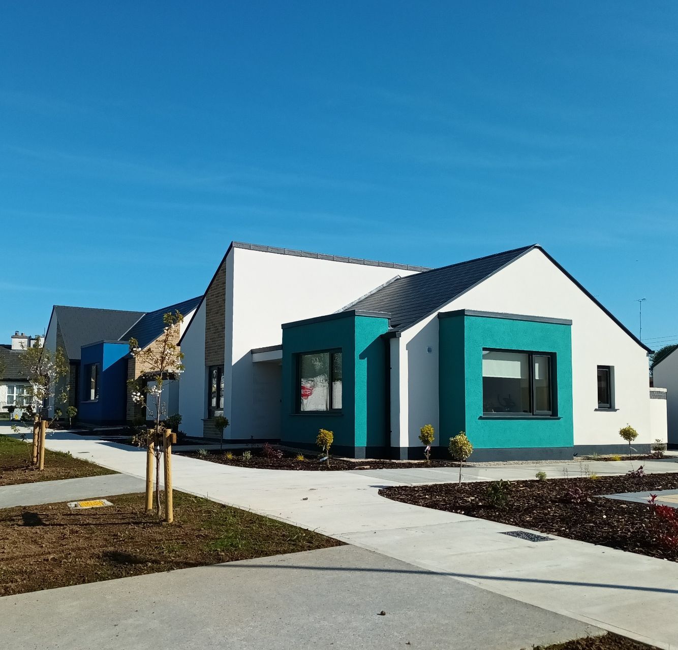A white house with a blue trim and a black roof