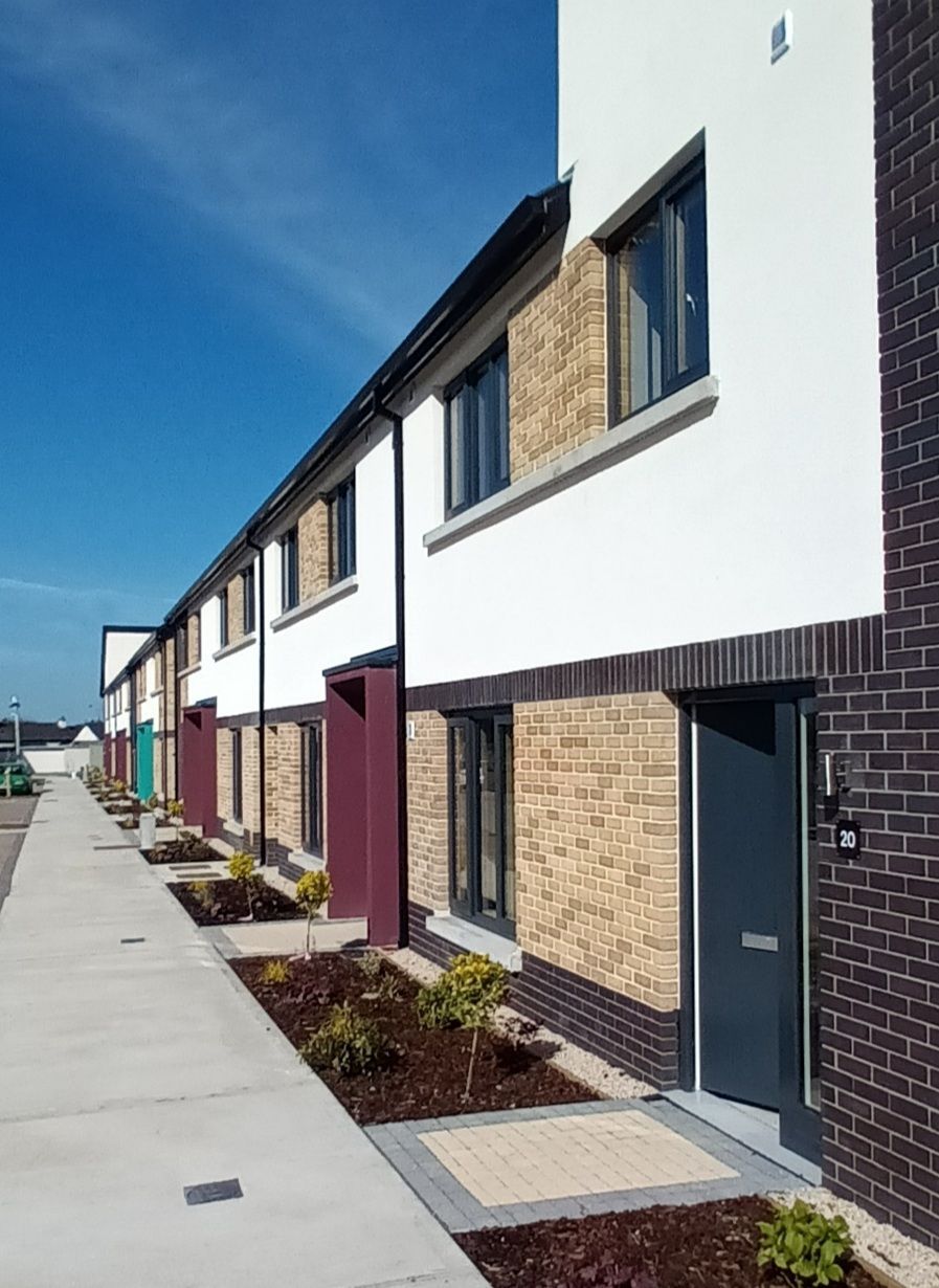 A row of houses with a sidewalk in front of them