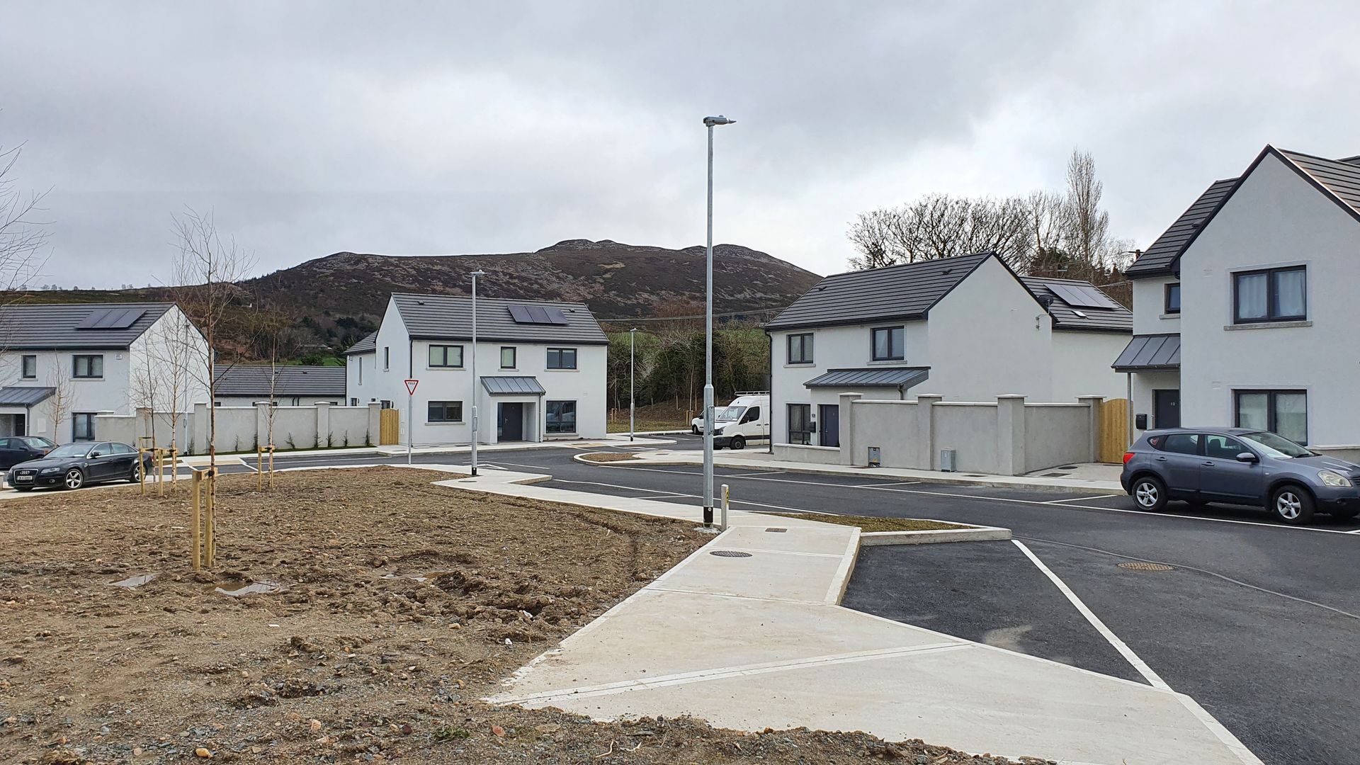 A row of houses are sitting next to each other on a dirt road.