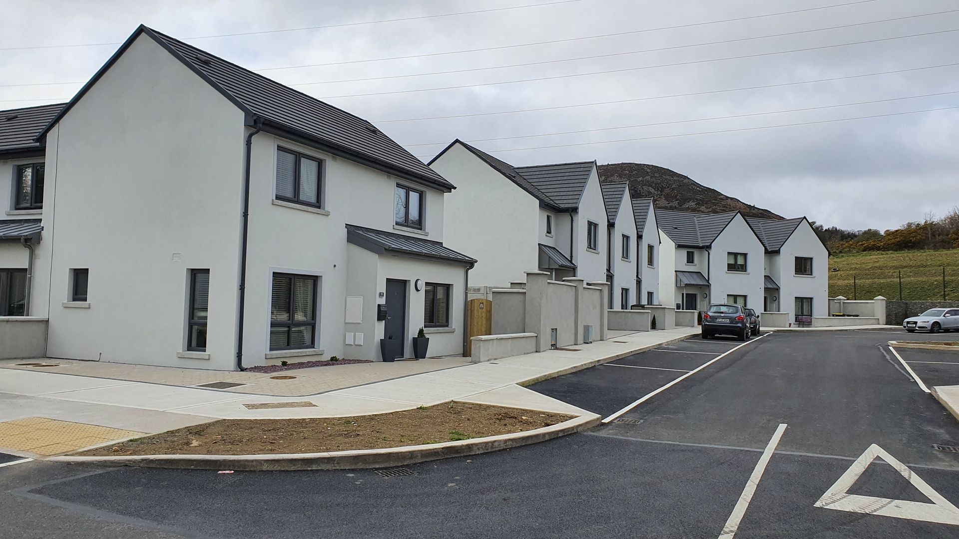 A row of white houses are lined up on a street