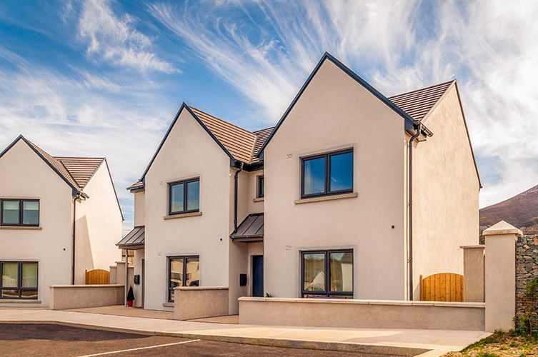 A row of white houses with a blue sky in the background