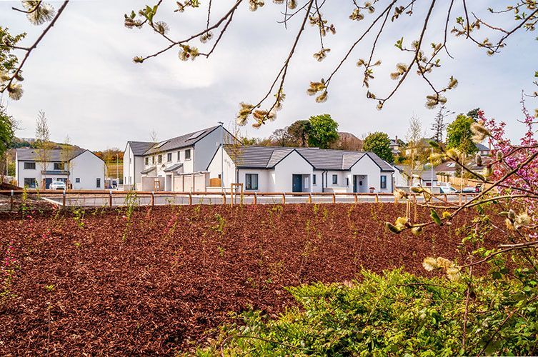 A row of houses are sitting on top of a dirt field.