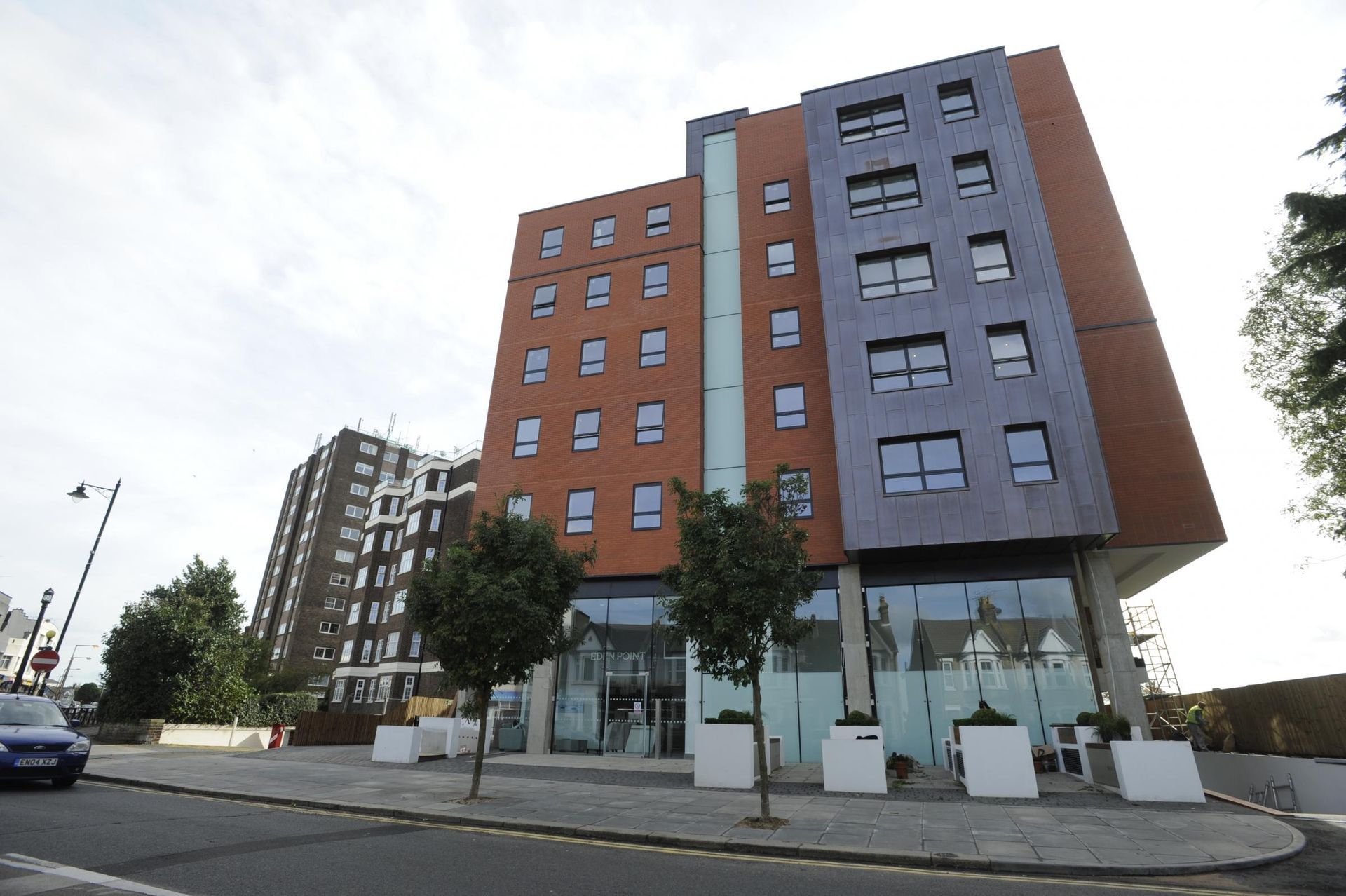 A tall building with a lot of windows and a car parked in front of it