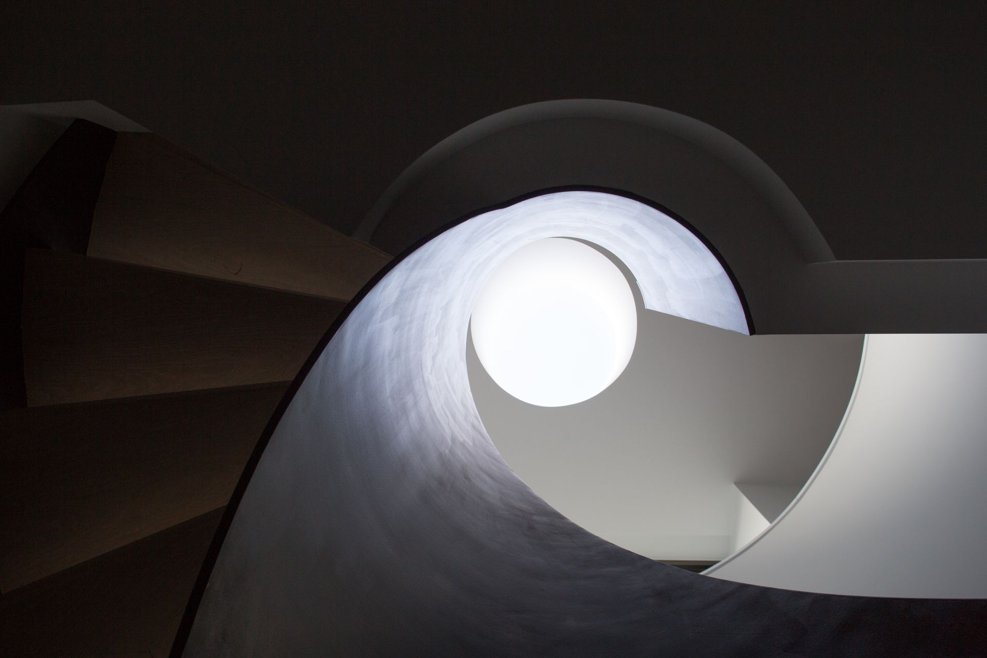 A spiral staircase with a light at the end