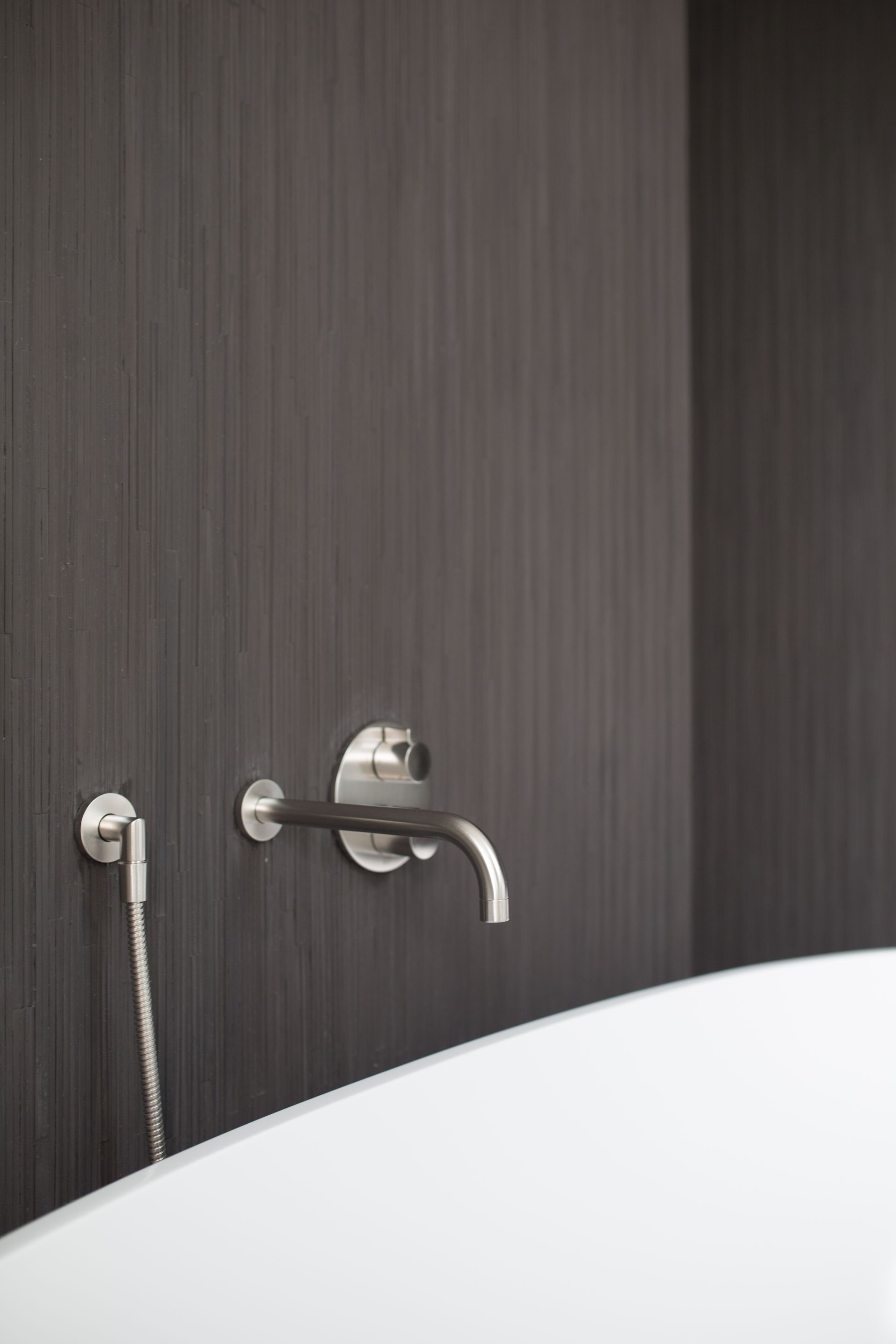 A bathroom with a bathtub and a faucet on the wall.
