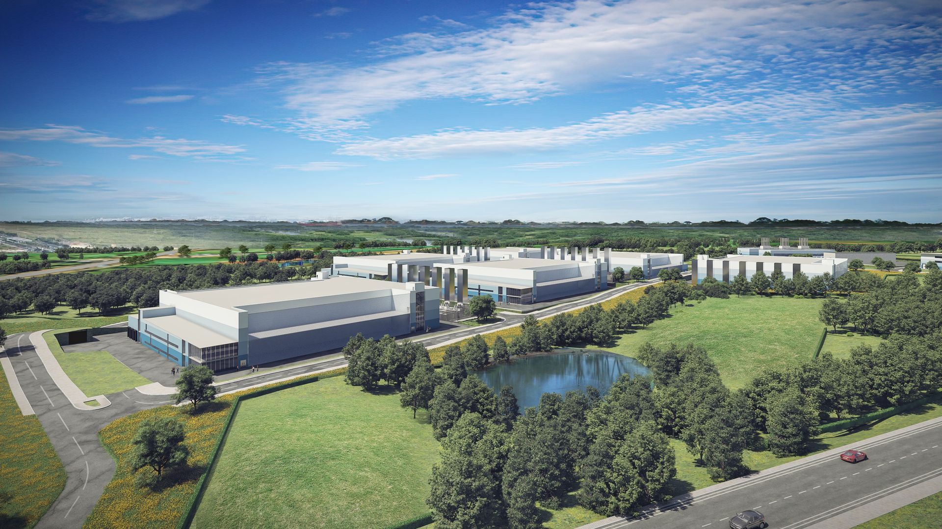 An aerial view of a large building surrounded by trees and a lake.