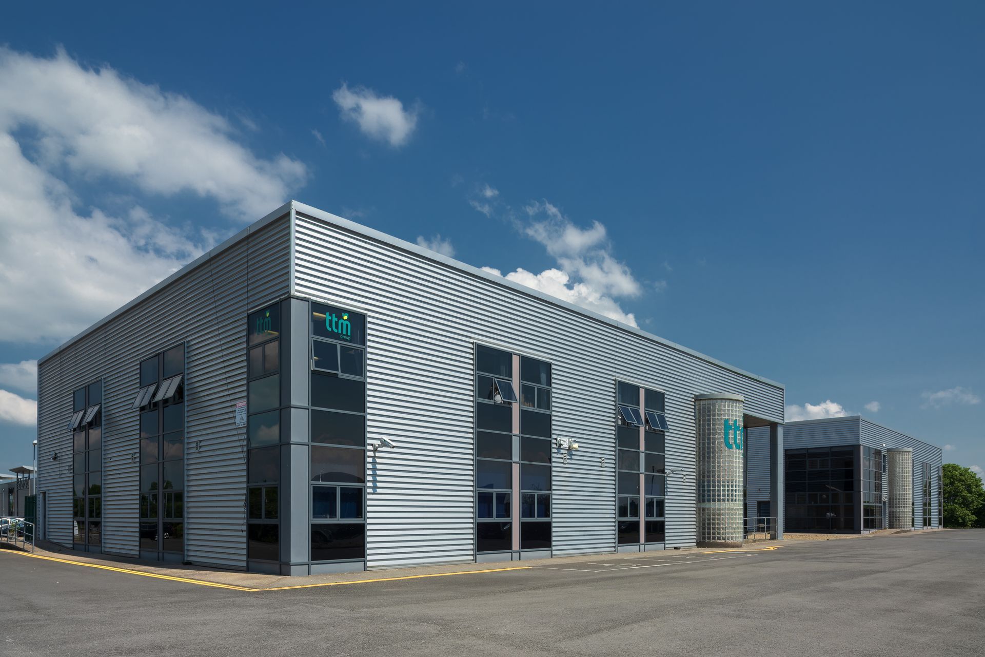 A large building with a lot of windows and a blue sky in the background.