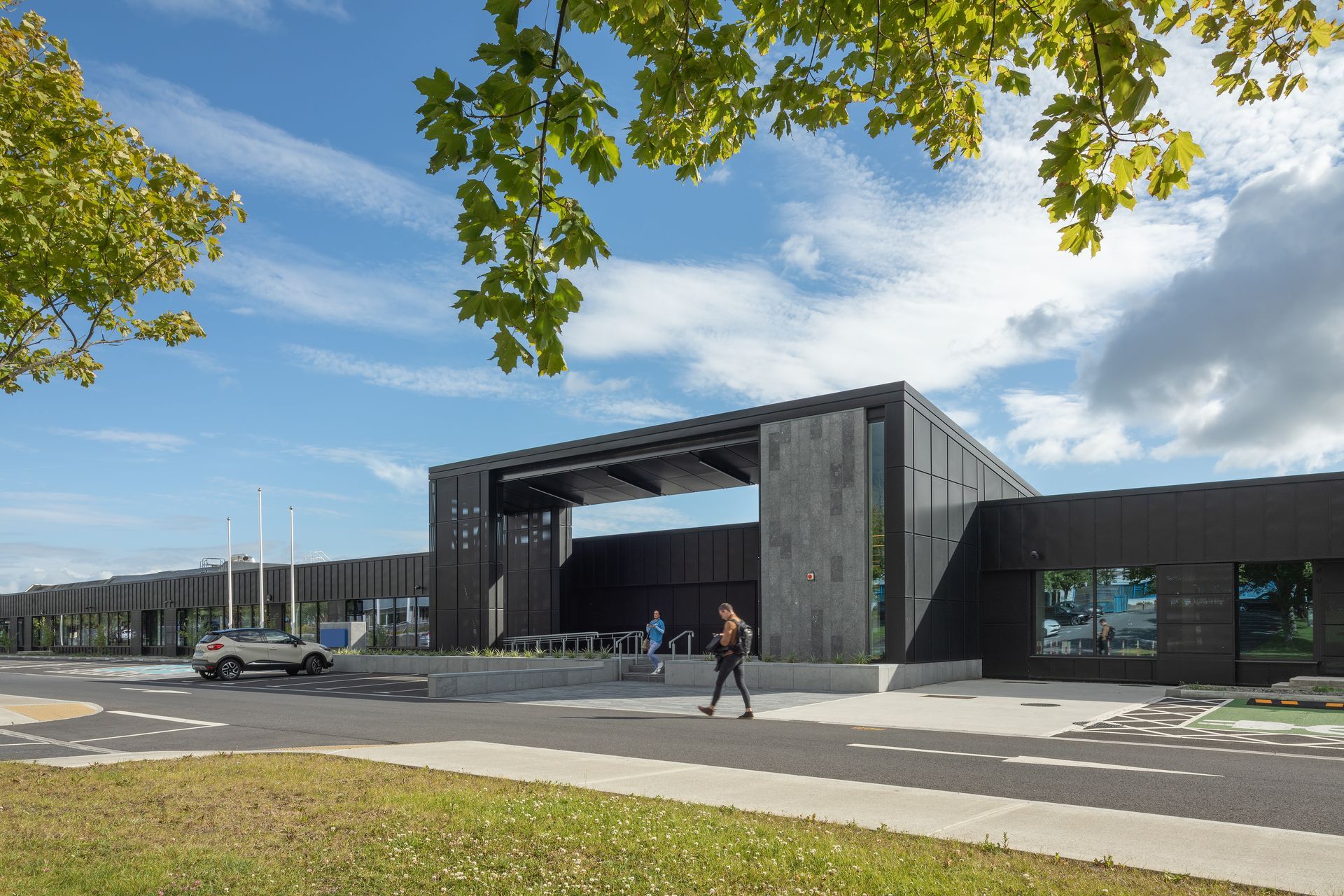A person is walking in front of a large building.