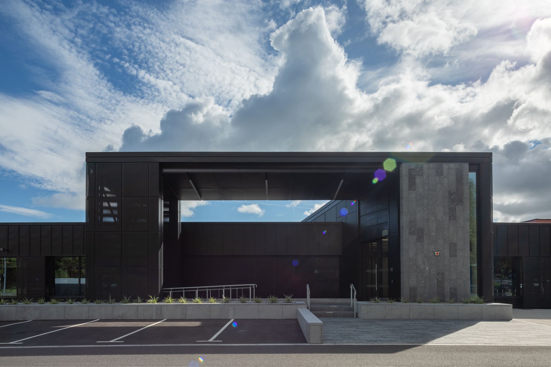 A large black building with a parking lot in front of it.