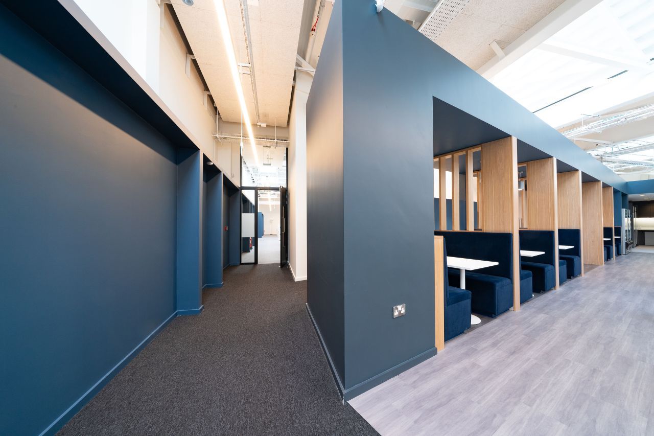 A hallway with a row of booths and tables