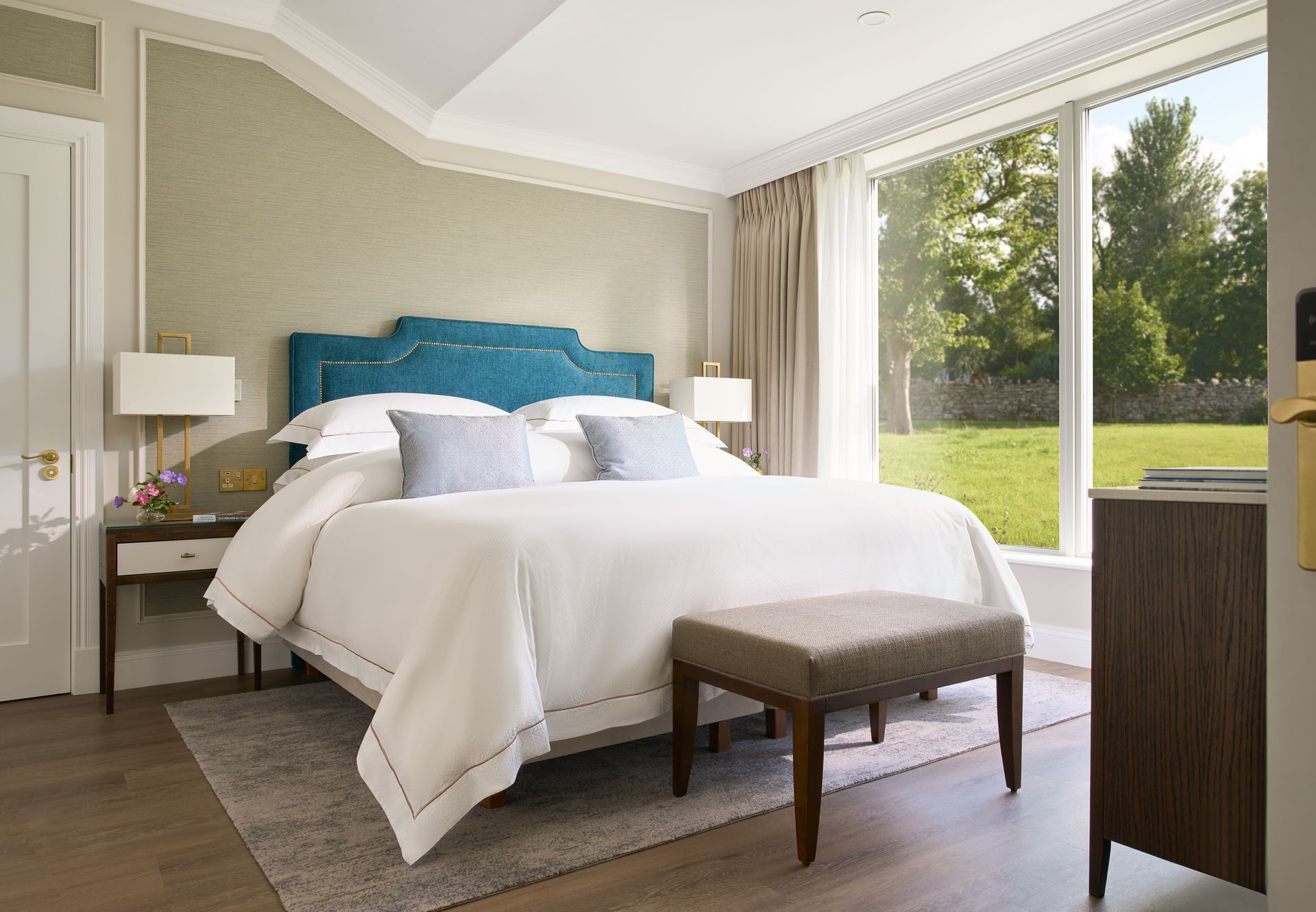 A bedroom with a king size bed and a large window.