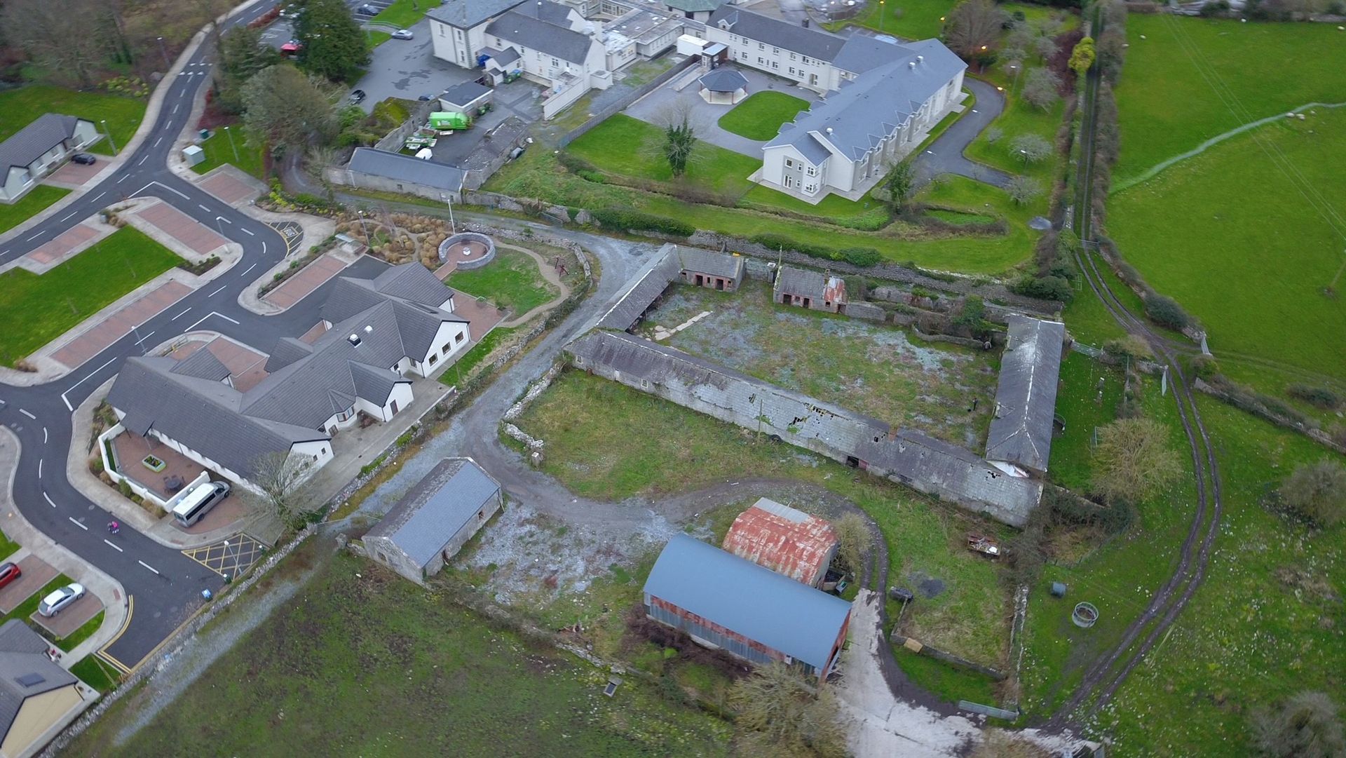 An aerial view of a residential area with a lot of buildings and fields.