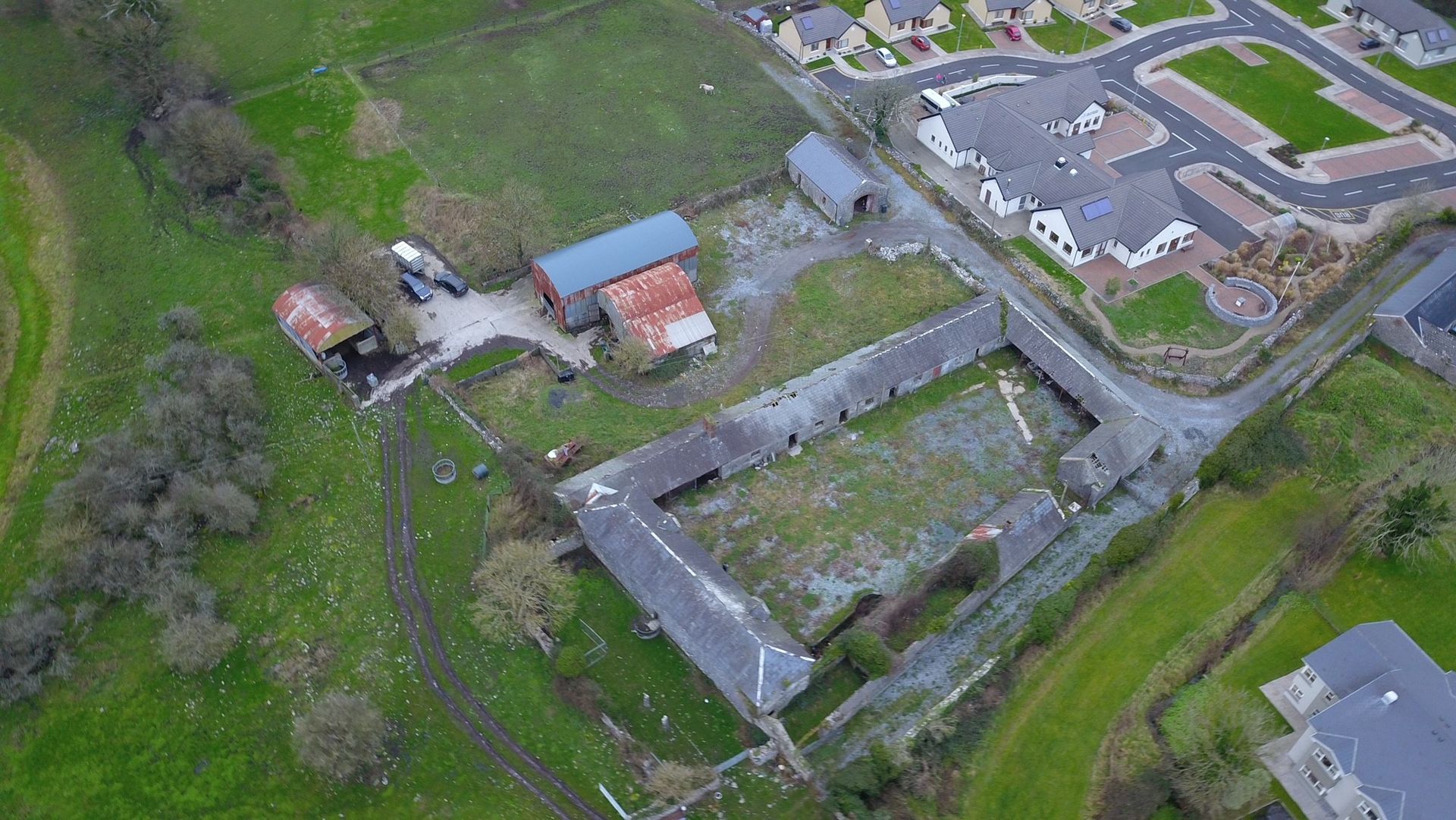 An aerial view of a farm and a residential area.