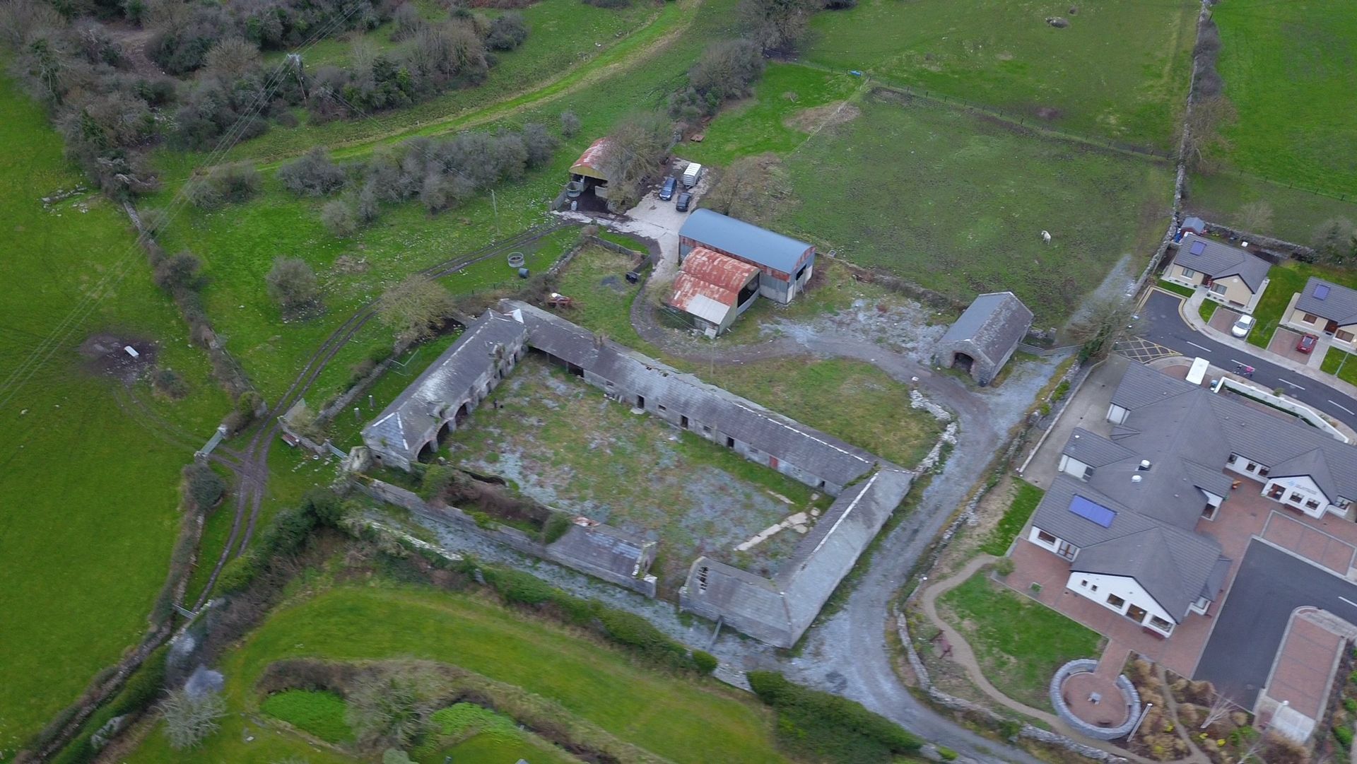 An aerial view of a farm with a lot of buildings and fields.