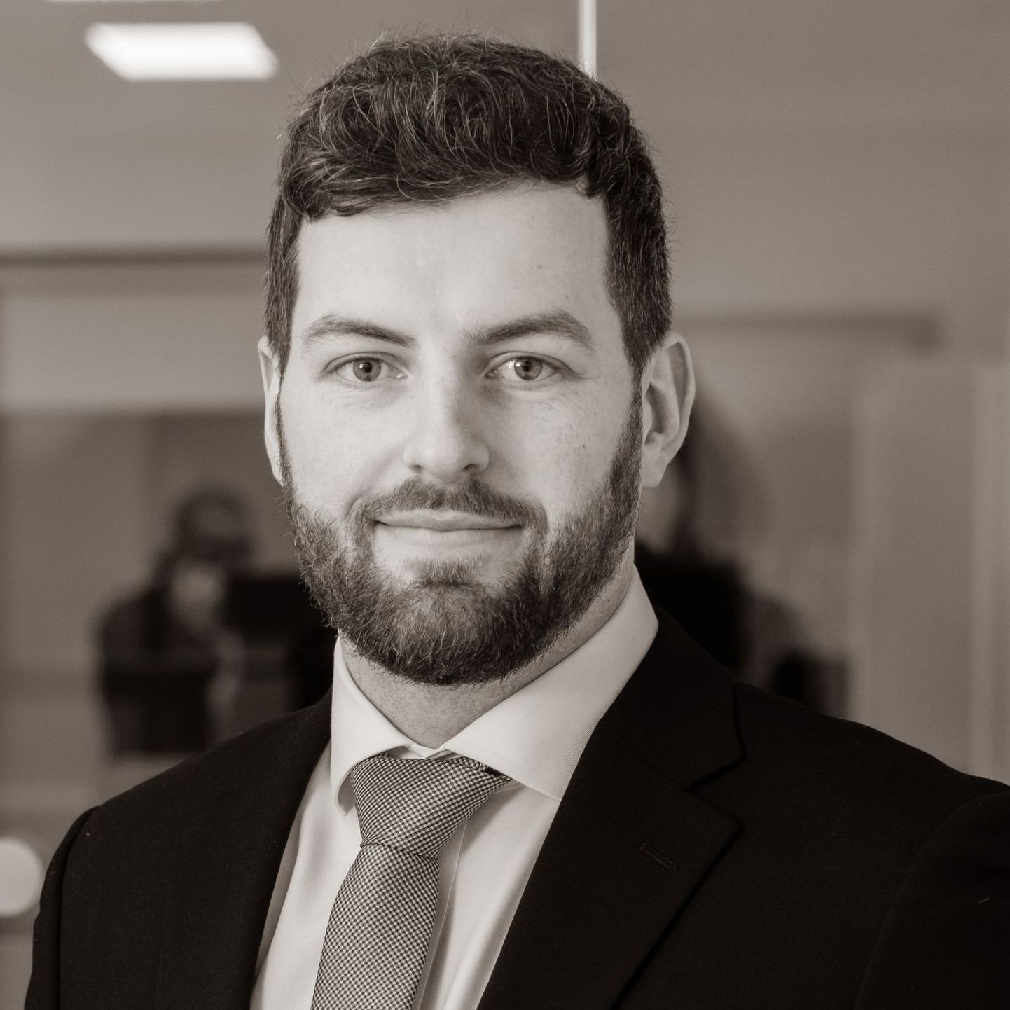 A man with a beard is wearing a suit and tie.